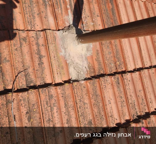 צינור מתכת עובר דרך רעפים עם תיקון בטון